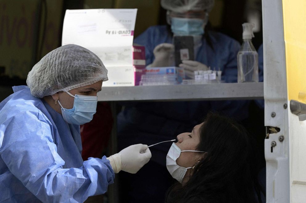 PHOTO: A health worker wearing protective gear collects a nasal swab for a COVID-19 PCR test at Plaza de Mayo square in Buenos Aires, Argentina, May 28, 2021.