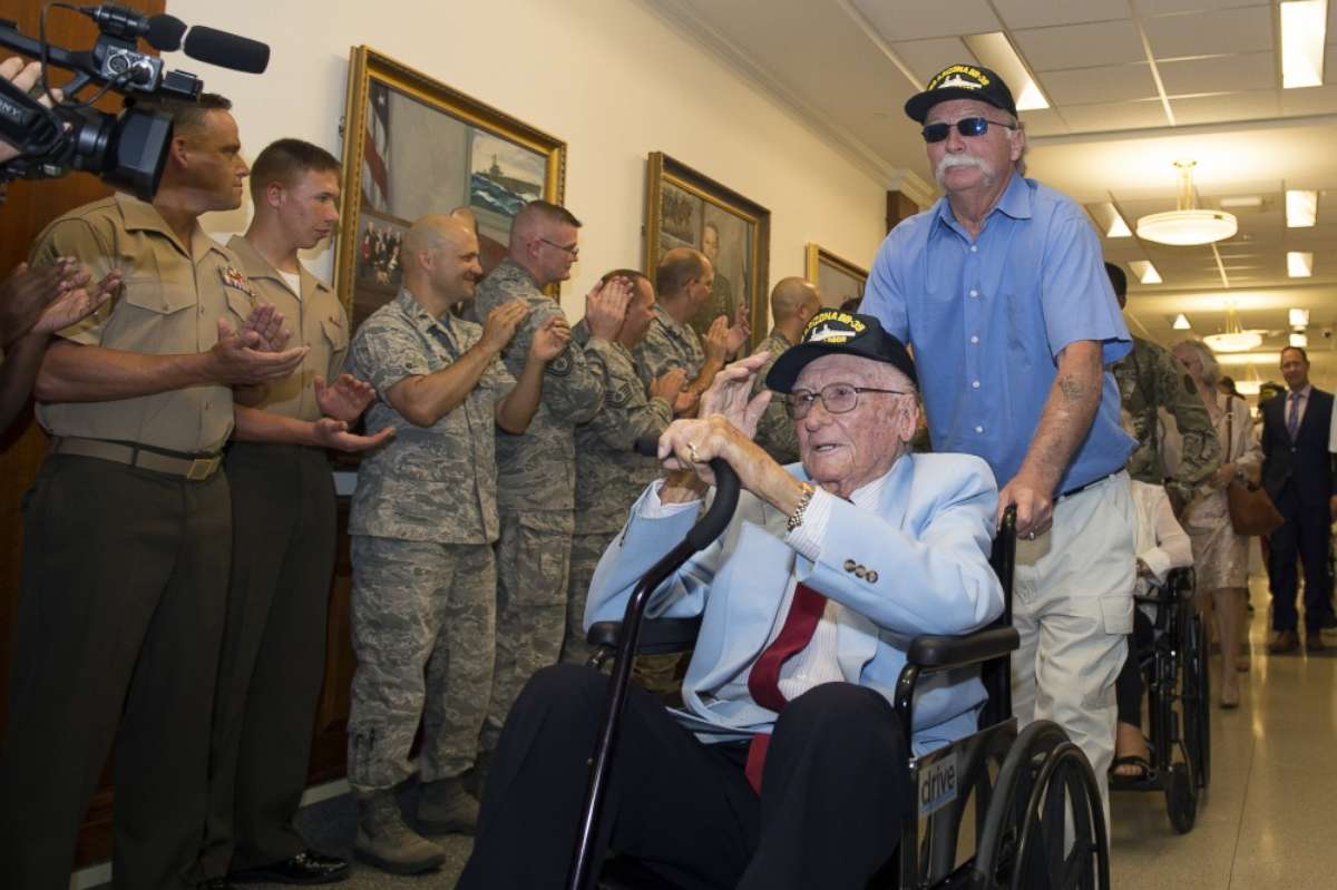 PHOTO: USS Arizona survivor Navy Seaman First Class Donald Stratton salutes while service members applaud him in the Pentagon in Arlington, Va. July 17, 2017. The Arizona was attacked at Pearl Harbor at the beginning of World War II. 
