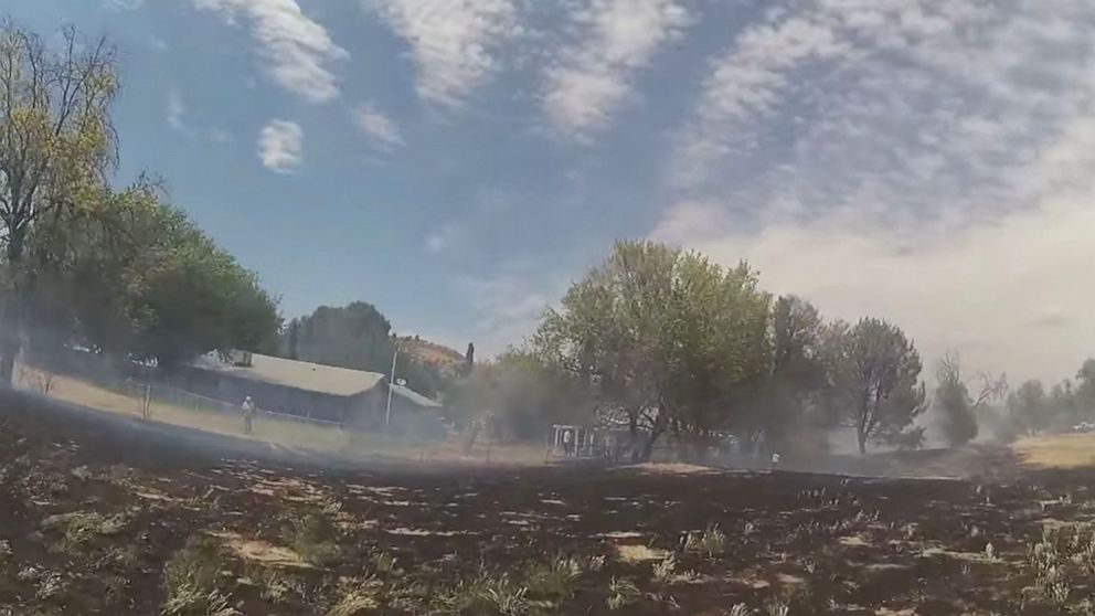 PHOTO: In this screen grab taken from a video posted to the Facebook account of the Yavapai County Sheriff's Office, people try to put out a brush fire near the Beaver Creek Golf Course.