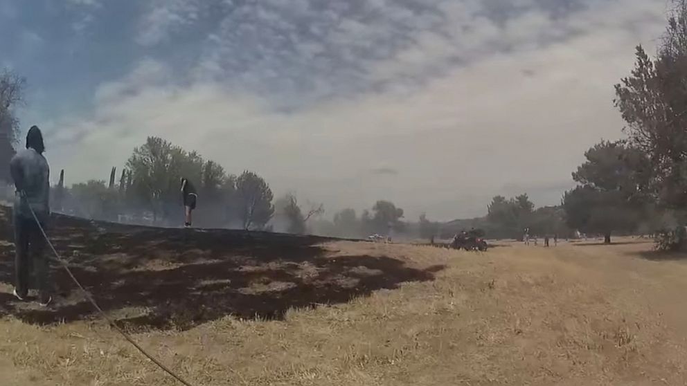 PHOTO: In this screen grab taken from a video posted to the Facebook account of the Yavapai County Sheriff's Office, people try to put out a brush fire near the Beaver Creek Golf Course.