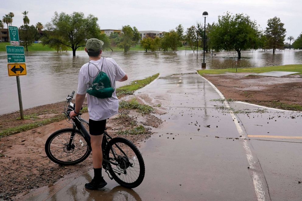 PHOTO: A cyclist is unable to continue his ride as heavy rains caused flooding at Vista del Camino Park, July 23, 2021, in Scottsdale, Ariz.