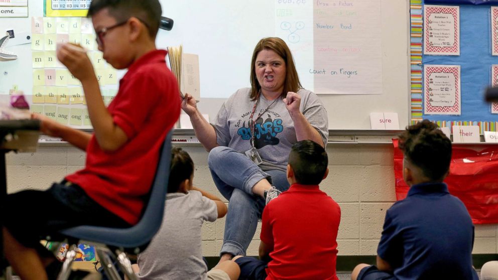 PHOTO: Third grade teacher Jennifer Boettcher reads a story to kids as they eat breakfast at San Marcos Elementary School, May 4, 2018, in Chandler, Ariz., after a statewide teachers strike ended.