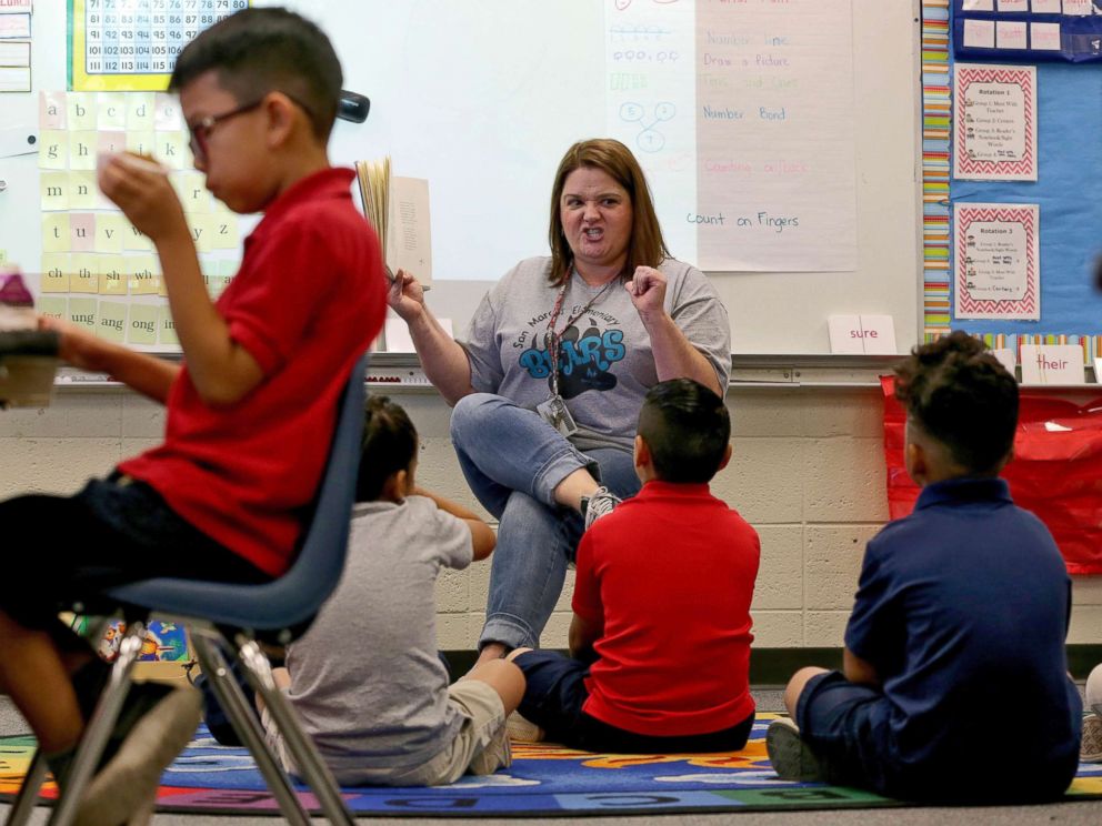 PHOTO: Third grade teacher Jennifer Boettcher reads a story to kids as they eat breakfast at San Marcos Elementary School, May 4, 2018, in Chandler, Ariz., after a statewide teachers strike ended.