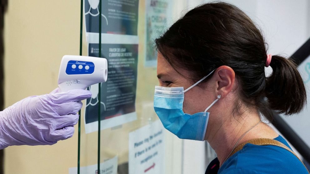 PHOTO: Jillian Golder, an employee of Oro Valley Hospital, has her temperature checked before receiving an antibody test for COVID-19 at the University of Arizona in Tucson, Arizona, July 10, 2020.