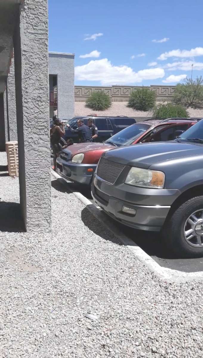 PHOTO: Cell phone video shows officers from the Phoenix Police Department after  sweep-kicking handcuffed Dravon Ames and pointing a gun at a pregnant mother with her two young daughters, May 27, 2019.