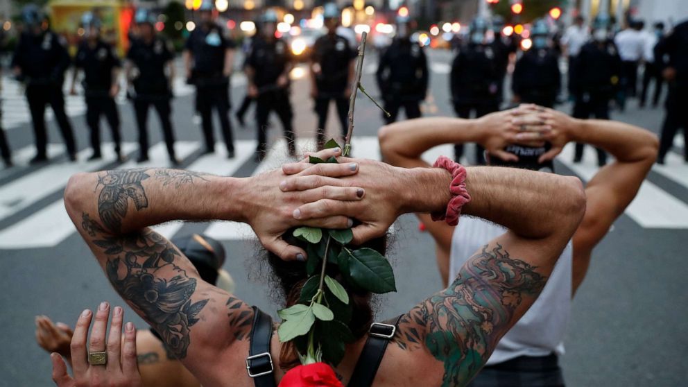PHOTO: Protesters kneel in front of New York City Police Department officers before being arrested for violating curfew beside the iconic Plaza Hotel on 59th Street, Wednesday, June 3, 2020, in New York.