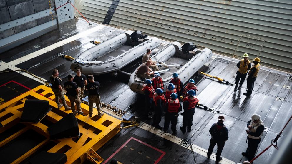 PHOTO: U.S. Navy personnel are seen in the well deck of USS John P. Murtha as they prepare equipment for the recovery of NASA's Orion spacecraft and extraction of the Artemis II crewmembers, April 8, 2026, off the coast of California. 