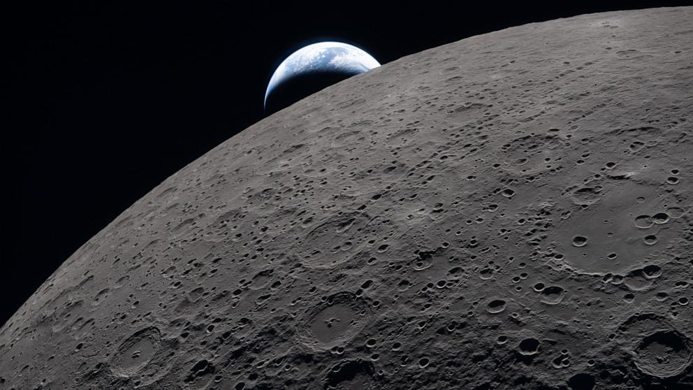 PHOTO: The lunar surface fills the frame in sharp detail, as seen during the Artemis II lunar flyby, while a distant Earth sets in the background, April 6, 2026.