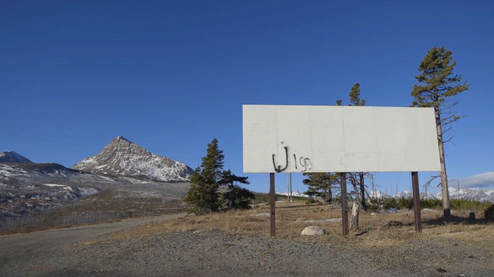 PHOTO: Graffiti adorns an empty billboard outside the town of St. Mary's on the Blackfeet Reservation in Montana.