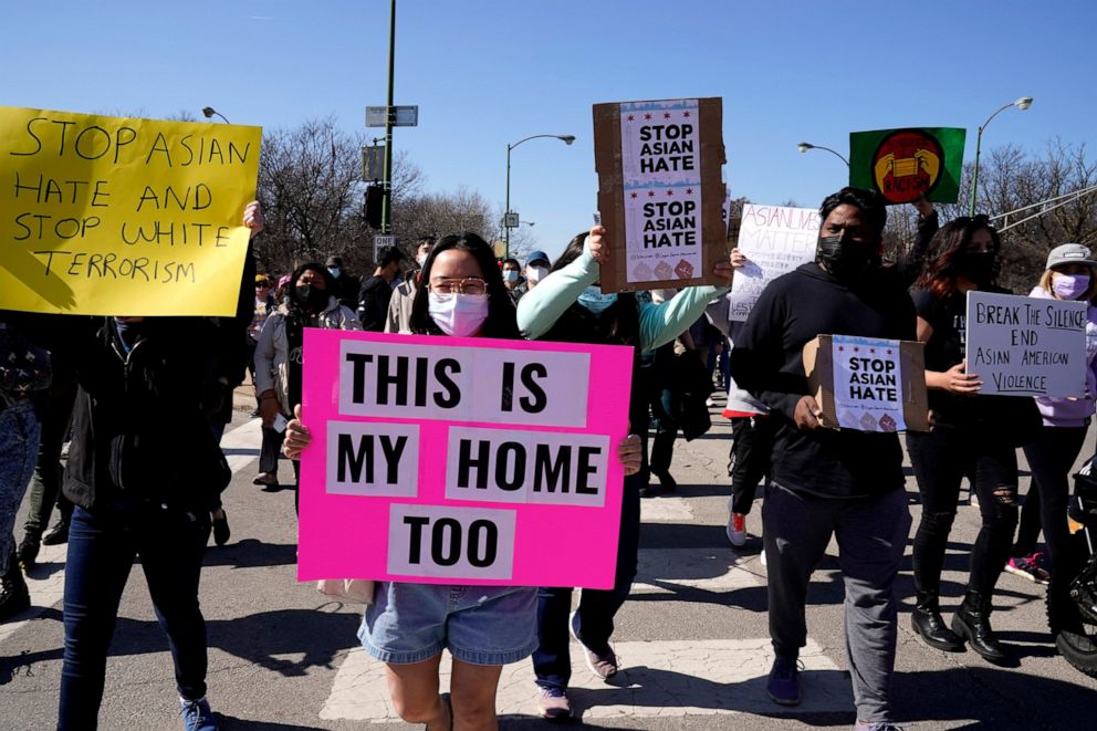 PHOTO: This March 20, 2021, file photo shows people holding signs as they march during a rally to support Stop Asian Hate at the Logan Square Monument in Chicago.
