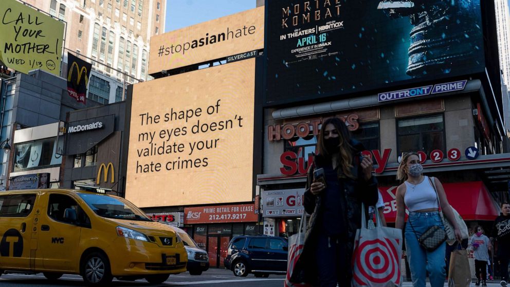 PHOTO: People walk past digital billboards display 'stop asian hate' messages near Penn Station in New York, March 30, 2021.