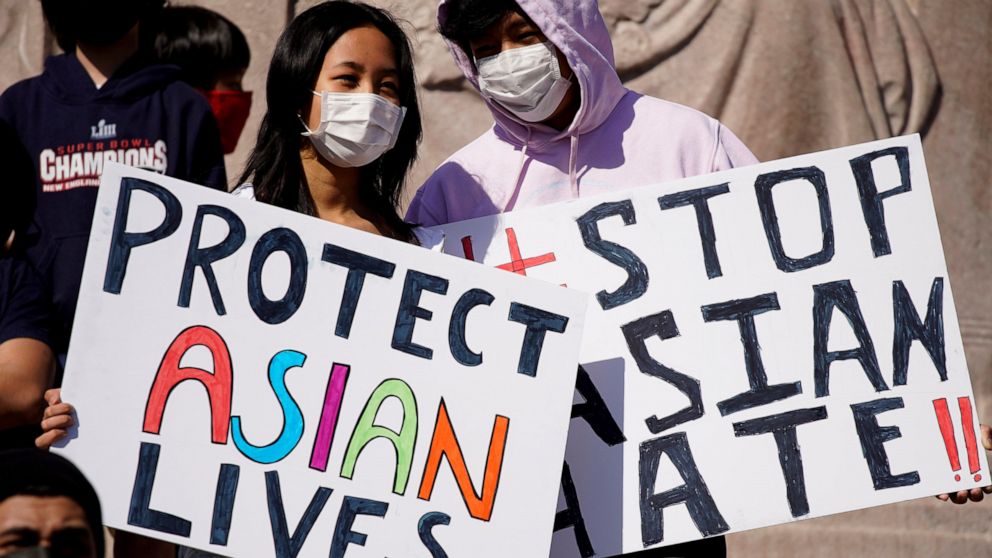 PHOTO: This March 20, 2021, file photo shows people holding signs as they attend a rally to support Stop Asian Hate at the Logan Square Monument in Chicago.