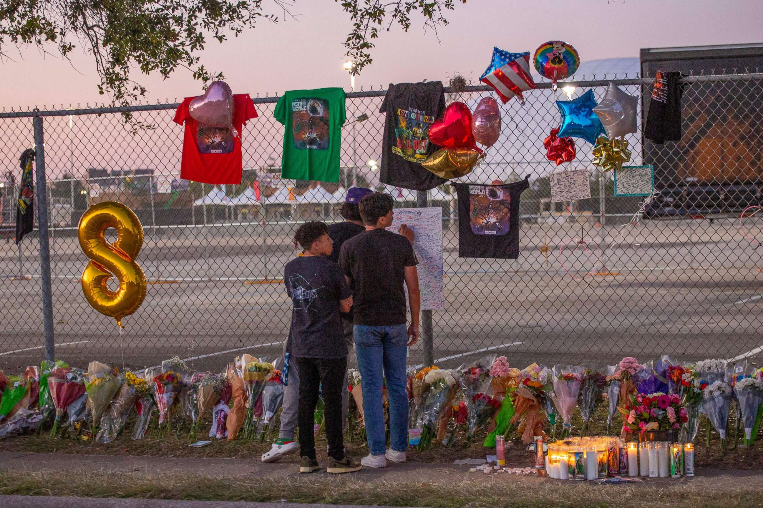 PHOTO: In this Nov. 7, 2021, file photo, local high school students who attended the Travis Scott concert sign a remembrance board at a makeshift memorial at the NRG Park grounds in Houston, Texas.