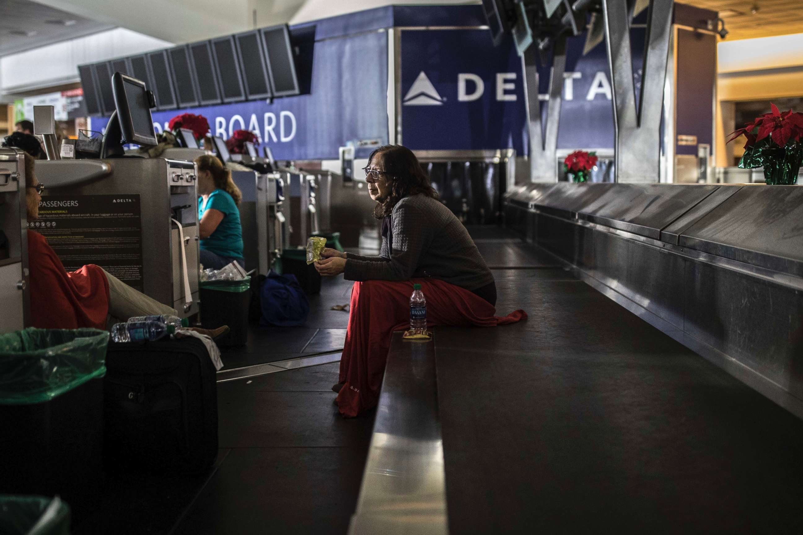 PHOTO: A passenger sits behind the ticket counter after the lights went out at Hartfield-Jackson Atlanta International Airport, Dec. 17, 2017, in Atlanta.