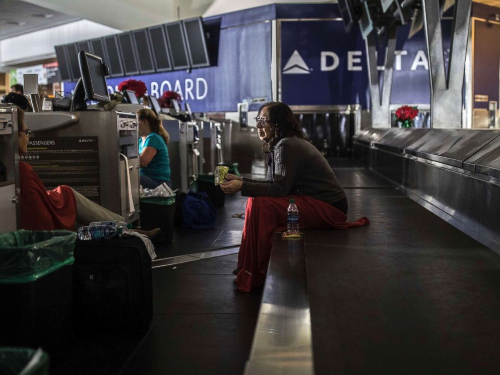 PHOTO: A passenger sits behind the ticket counter after the lights went out at Hartfield-Jackson Atlanta International Airport, Dec. 17, 2017, in Atlanta.