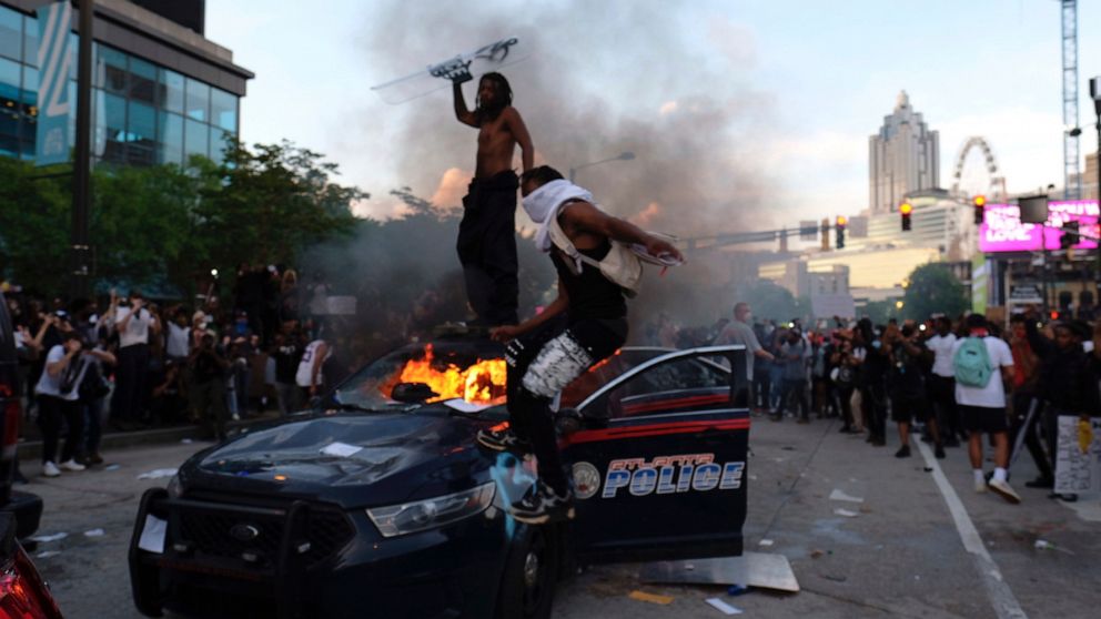 PHOTO: Protesters smash police cars in Atlanta, Friday, May 29, 2020. Protesters marched for George Floyd, who died after being restrained by Minneapolis police officers on Memorial Day.