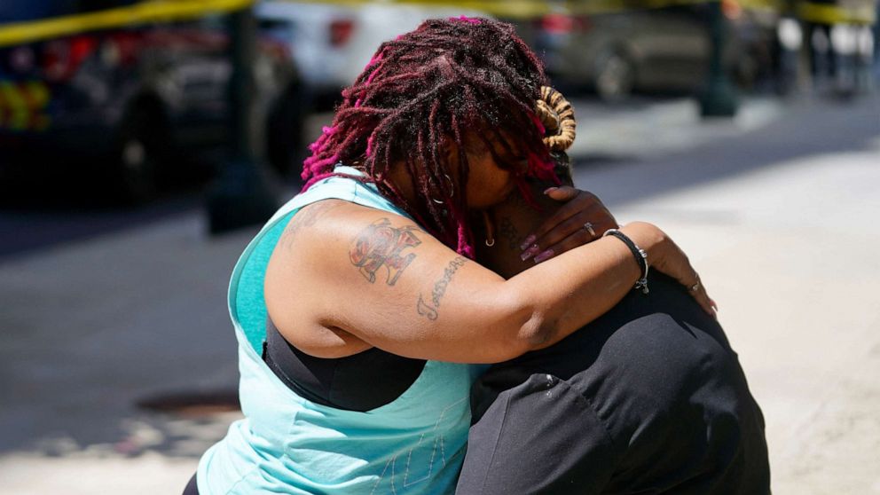 PHOTO: Two women embrace near the scene where a man shot five people inside a building in Atlanta, Georgia, on May 3, 2023.