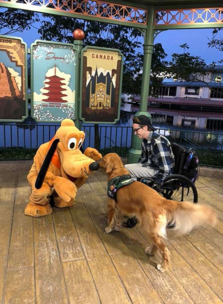 PHOTO: Julian Gavino's Golden Retriever service dog Atlas meets the giant version of Disney character Pluto at Epcot Center in Orlando, Fla., Jan. 19, 2018.