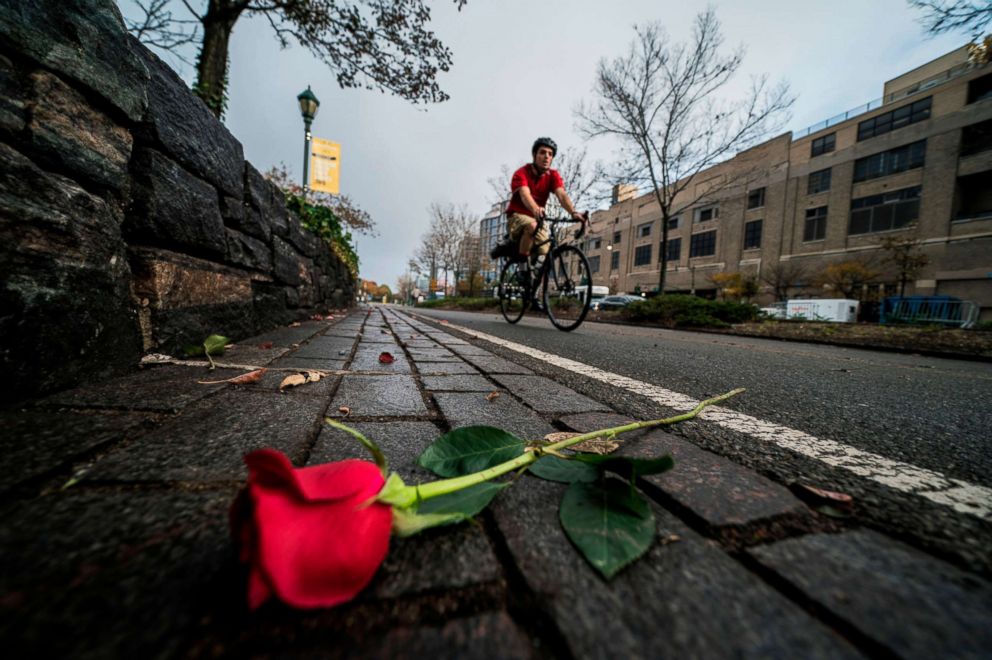 PHOTO: A cyclist rides past flowers left on a bike path to pay tribute to the October 31 terror attack victims, in New York, on November 2, 2017.