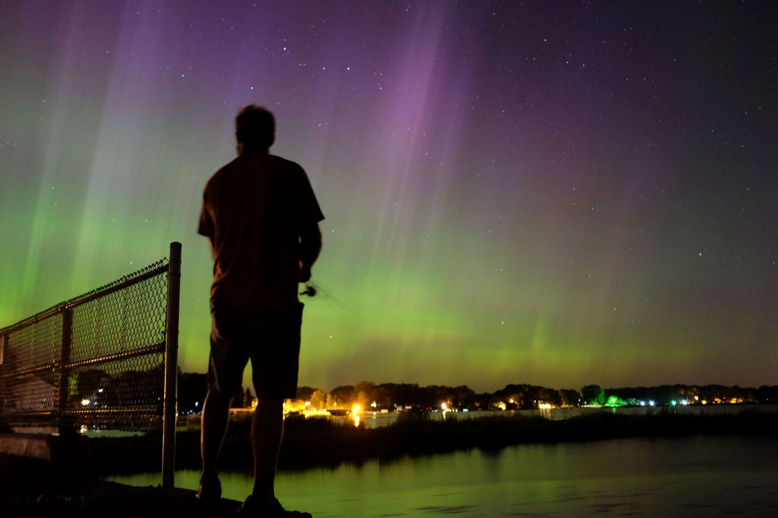 PHOTO: Wade Kitner looks at the northern lights as he fishes in Ventura, Iowa, June 23, 2015.