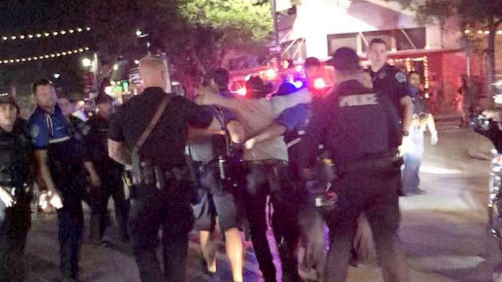 PHOTO: Police officers escort a victim (C) after gunfire erupted at a busy entertainment district in Austin, Texas, June 12, 2021, in this still image taken from video provided on social media.