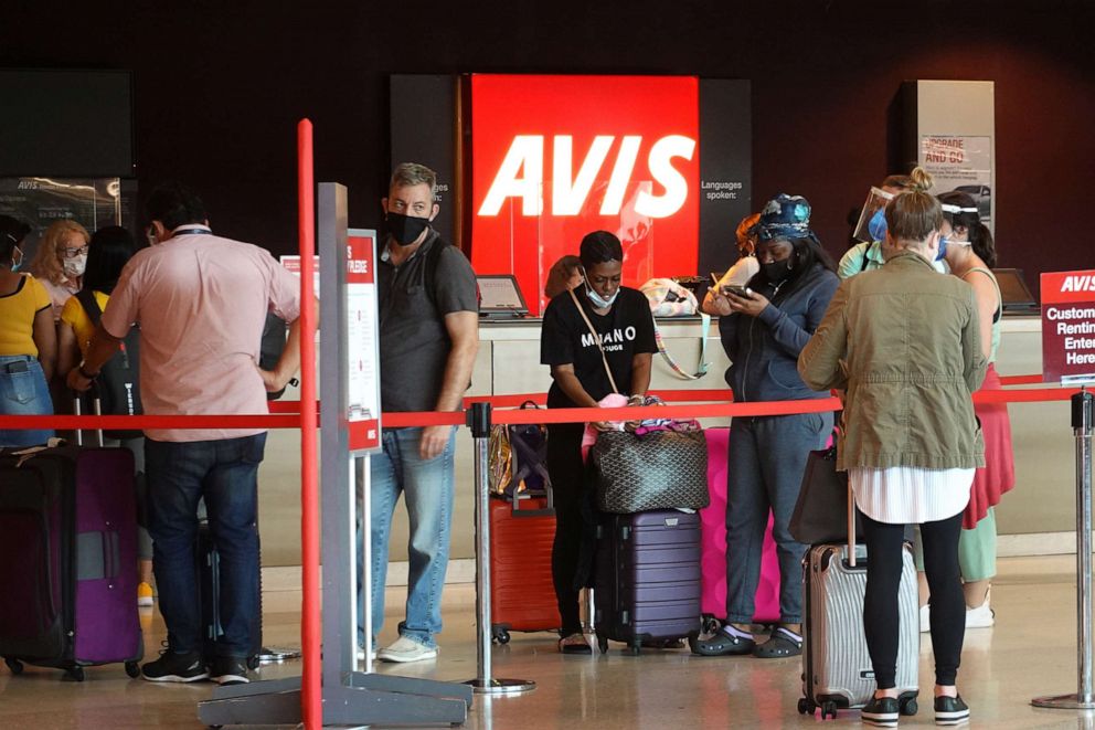 PHOTO: People wait in line at Avis rental agency in the Miami International Airport Car Rental Center, April 12, 2021, in Miami.
