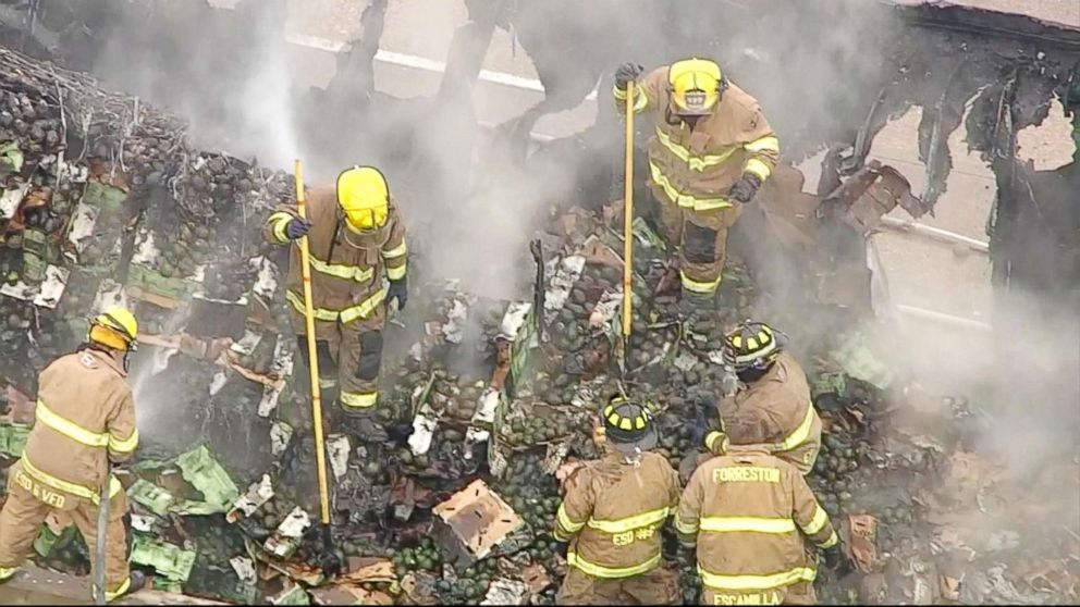 PHOTO: Firefighters attend to the scene where an 18-wheeler spilled about 40,000 pounds of avocados onto a Texas highway, Dec. 12, 2017.