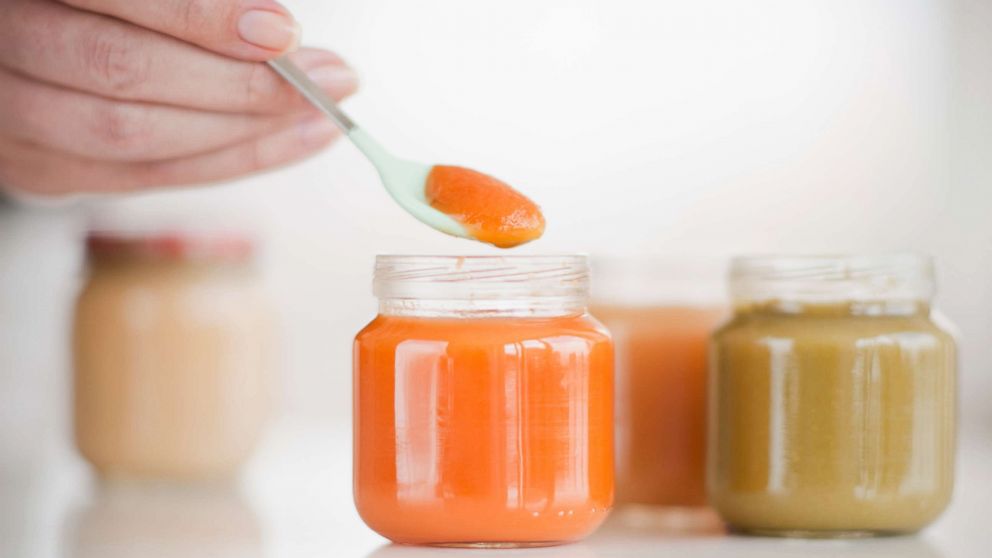 PHOTO: Hand spooning baby food.