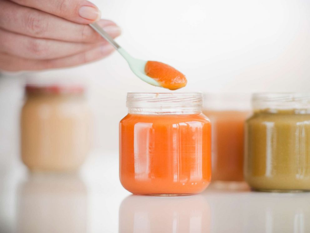 PHOTO: Hand spooning baby food.