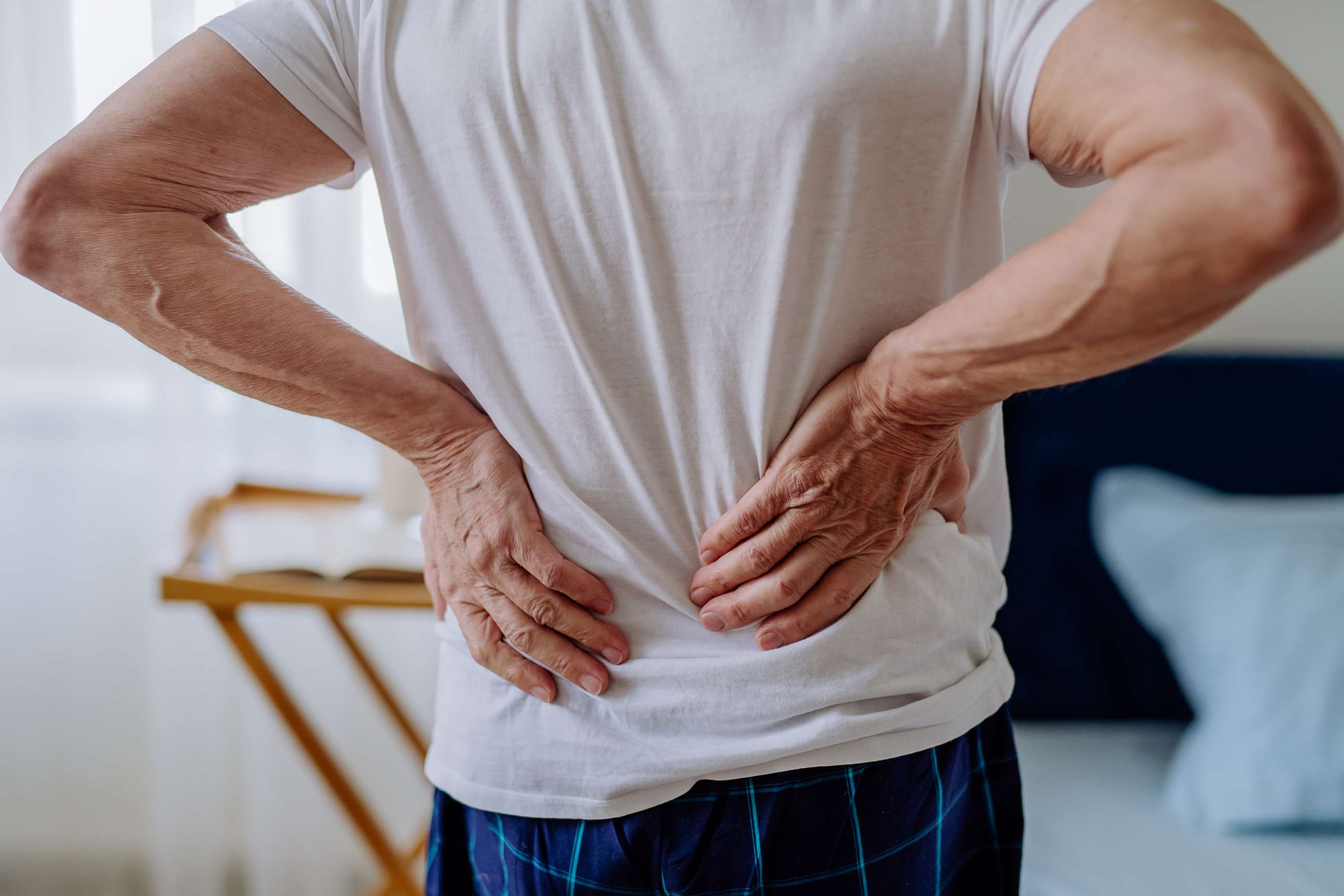 PHOTO: A man holds his back in an undated stock photo.