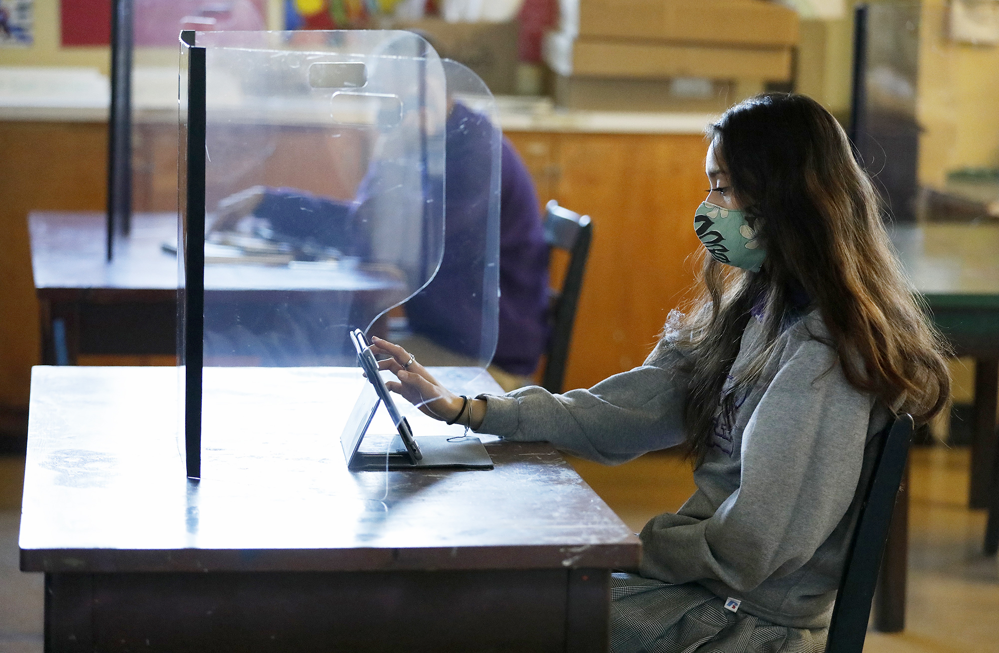 PHOTO: Senior student Ariana Diaz works with a plexiglass barrier in the art classroom as students return to in-person instruction in Long Beach, Calif., March 24, 2021.