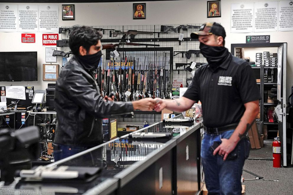 PHOTO: A customer hands over his ID for a background check to a manager before making a purchase at Firearms Unknown, a gun store in Oceanside, Calif., April 12, 2021. 