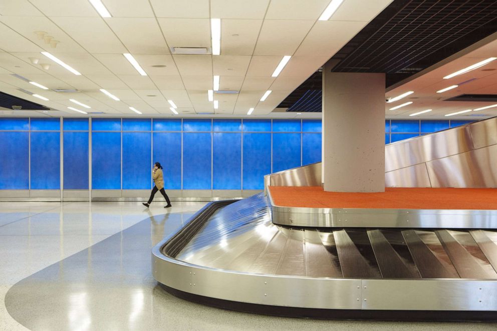 PHOTO: A person walks through the baggage claim hall in Terminal 5 at John F. Kennedy International Airport in New York, April 9, 2020.