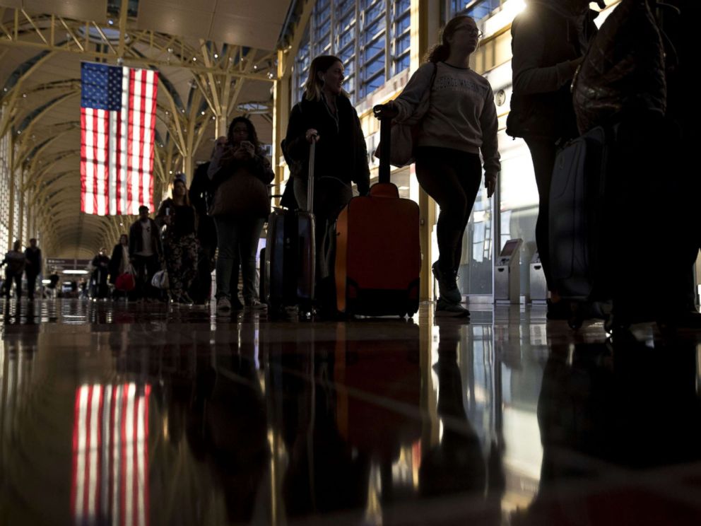 PHOTO: An American flag hangs above travelers waiting in line before going through Transportation Security Administration (TSA) screening at Ronald Reagan National Airport (DCA) in Washington, D.C., Nov. 23, 2016.
