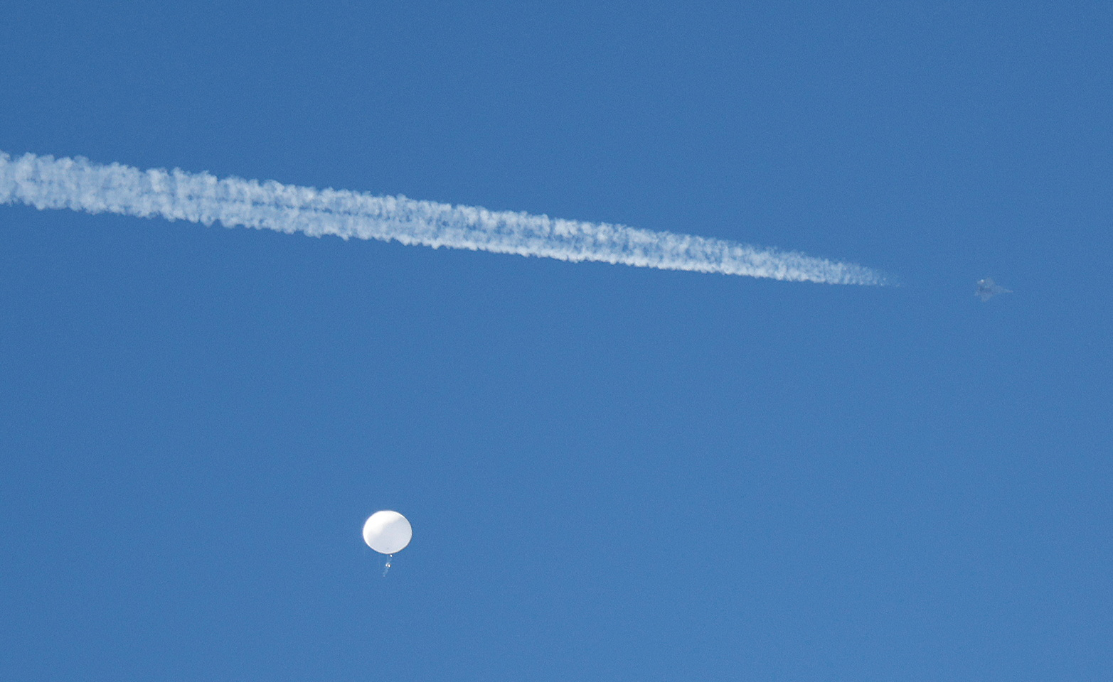 PHOTO: A jet flies by a suspected Chinese spy balloon as it floats off the coast in Surfside Beach, South Carolina, Feb. 4, 2023.