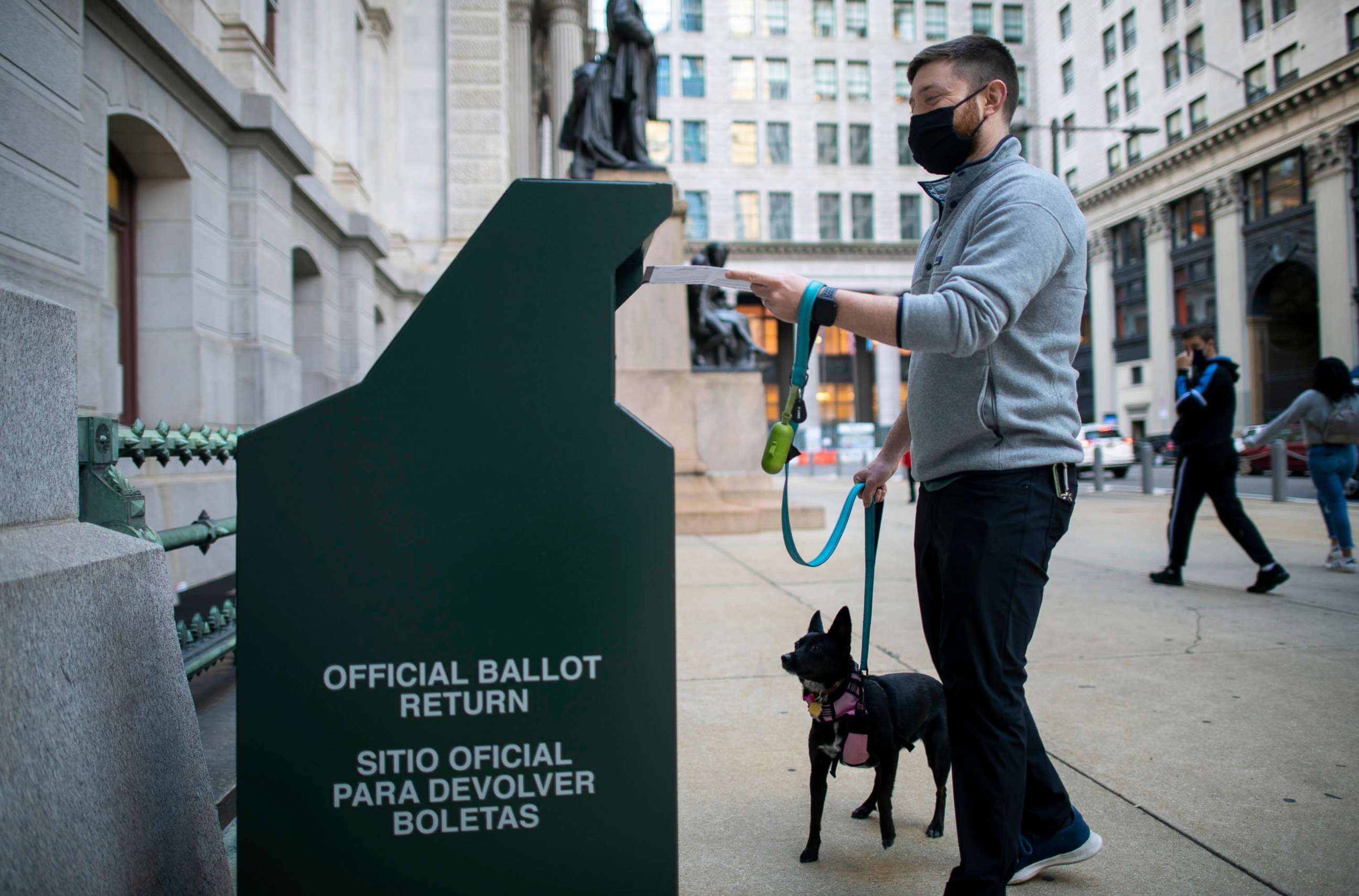 PHOTO: A voter casts his early voting ballot at drop box outside of City Hall on October 17, 2020, in Philadelphia.