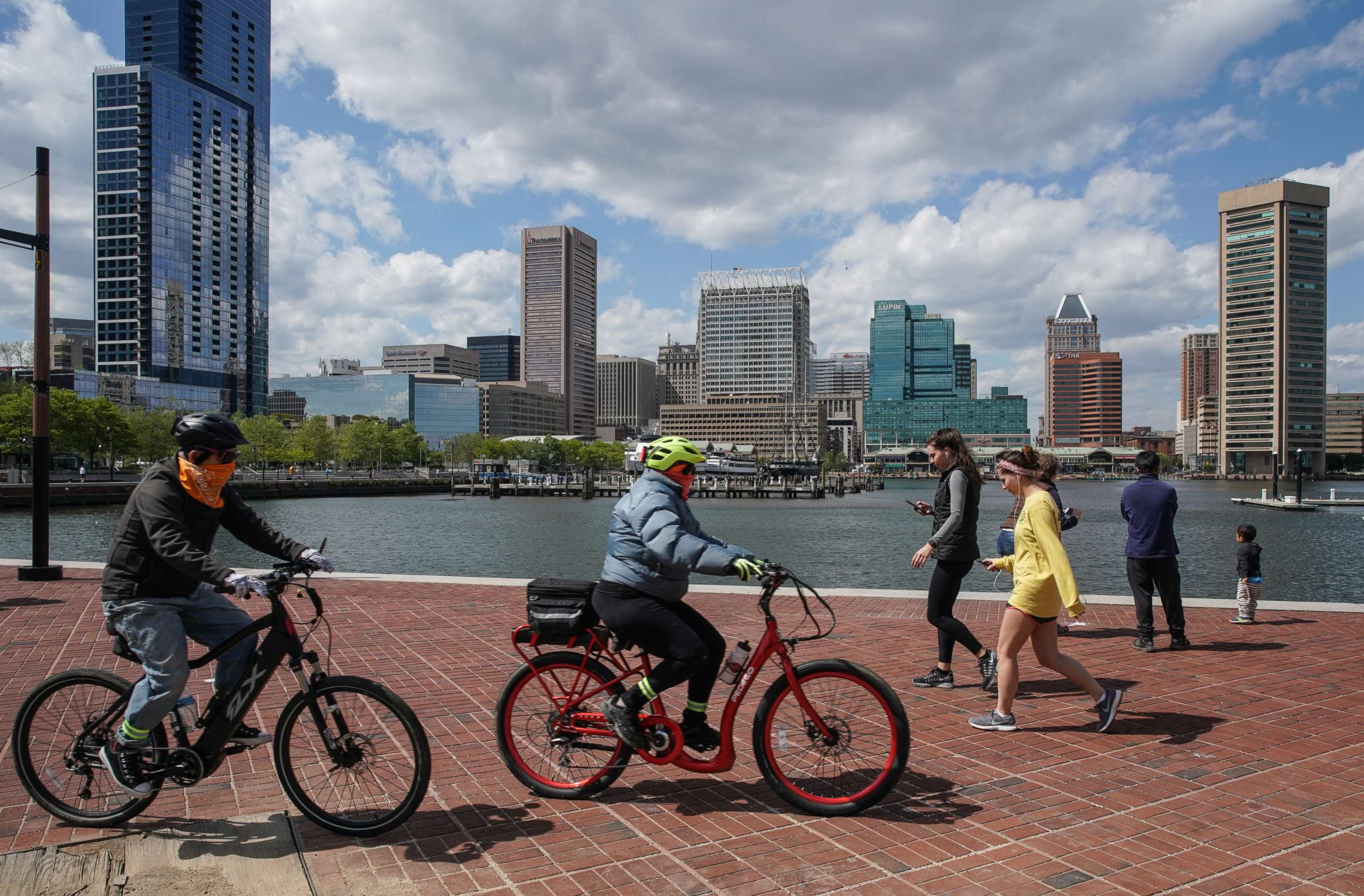 PHOTO: Baltimore residents walk and bike along the Inner Harbor promenade on May 12, 2020 in Baltimore.