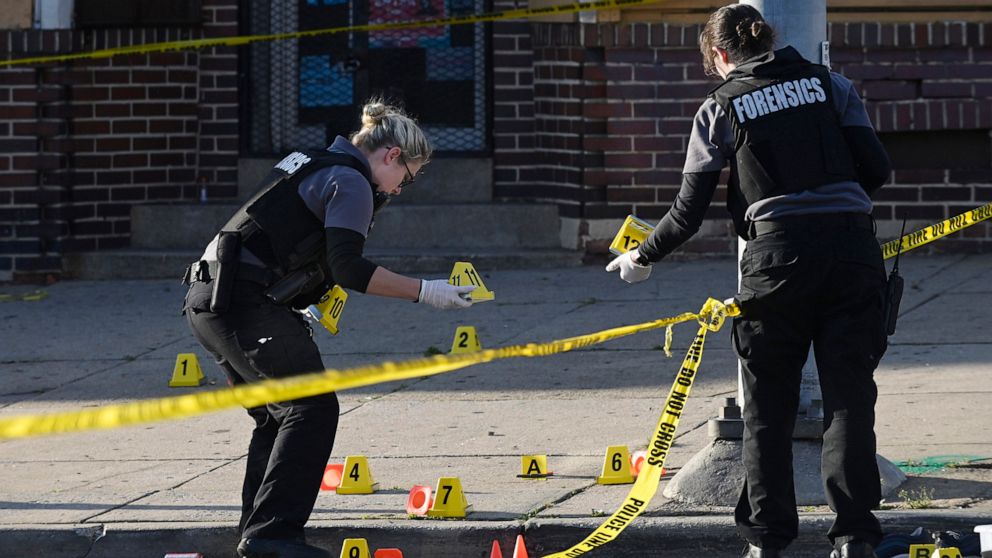 PHOTO: In this April 28, 2019, file photo, police forensics officers place evidence markers next to bullet casings while investigating the scene of a mass shooting at Edmondson and Whitmore Avenues in Baltimore.
