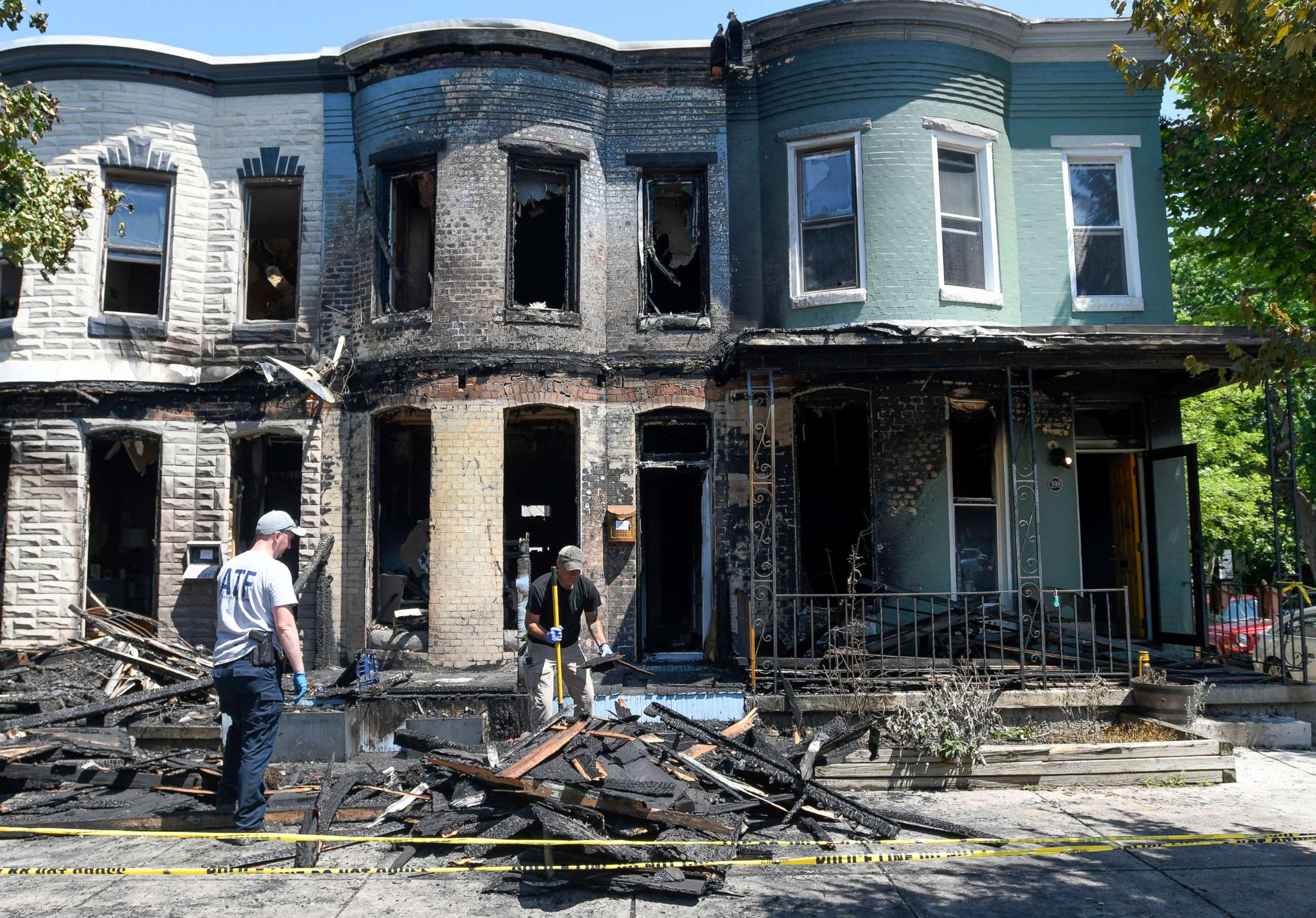 PHOTO: Fire investigators work at the scene of a row house fire in Baltimore, on June 15, 2022.