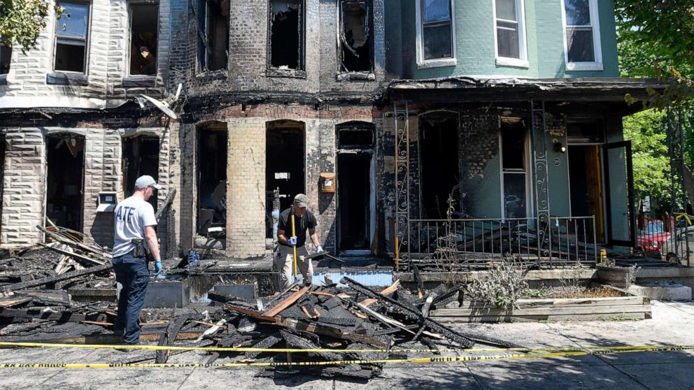 PHOTO: Fire investigators work at the scene of a row house fire in Baltimore, on June 15, 2022.