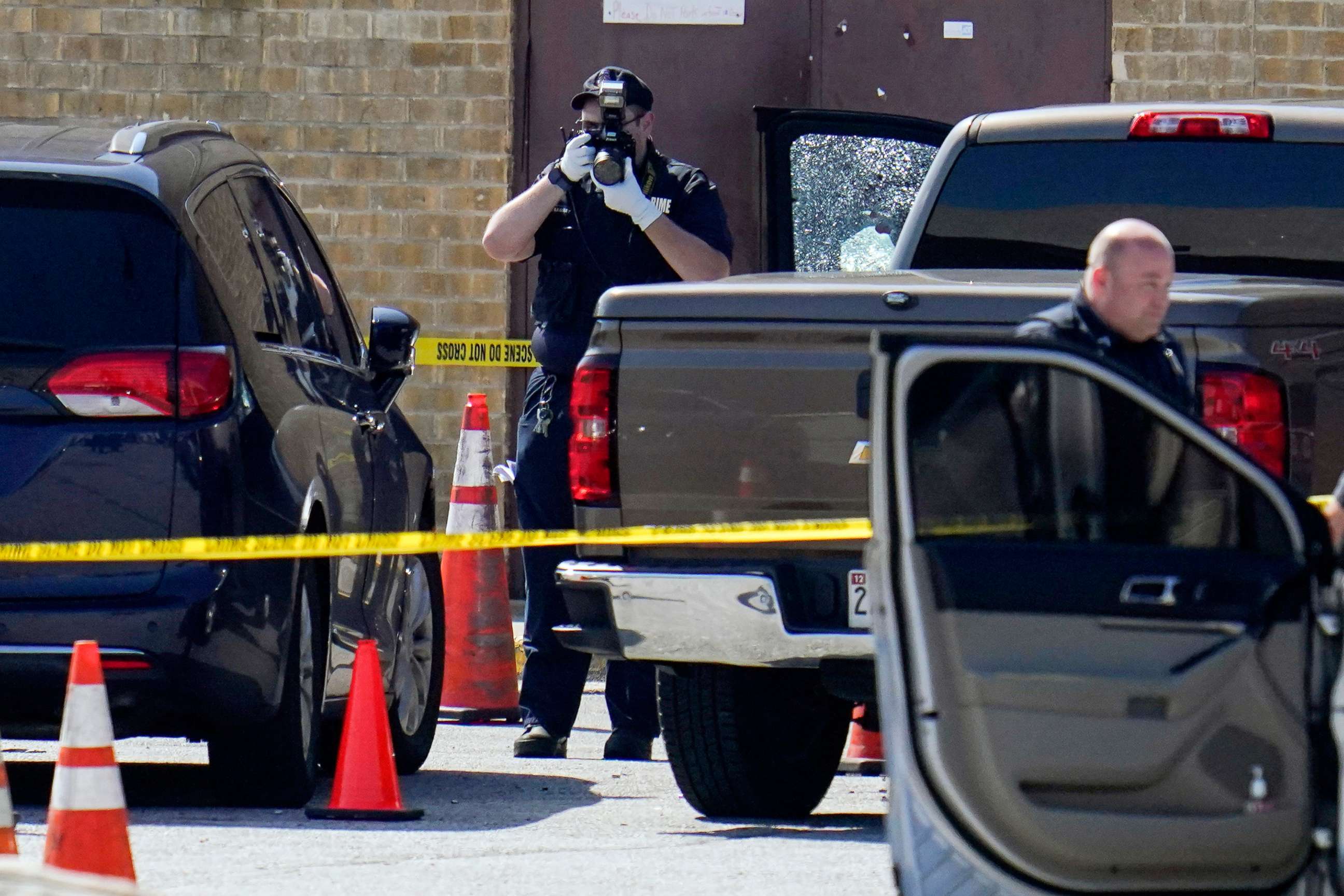 PHOTO: Shattered glass is seen on a pickup's driver side door as investigators document the scene in a mall parking area where two Baltimore city police officers were shot and a suspect was killed, July 13, 2021, in Baltimore.