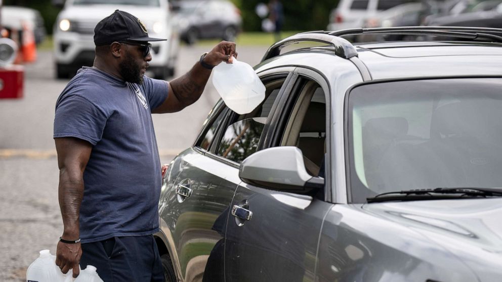 PHOTO: Workers with the Baltimore City Department of Public Works distribute jugs of water to city residents at the Landsdowne Branch of the Baltimore County Library on September 6, 2022 in Baltimore, Maryland. 