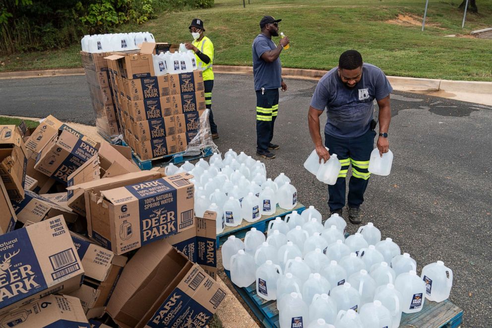 PHOTO: Workers with the Baltimore City Department of Public Works distribute jugs of water to city residents at the Landsdowne Branch of the Baltimore County Library on Sept. 6, 2022 in Baltimore, Maryland.