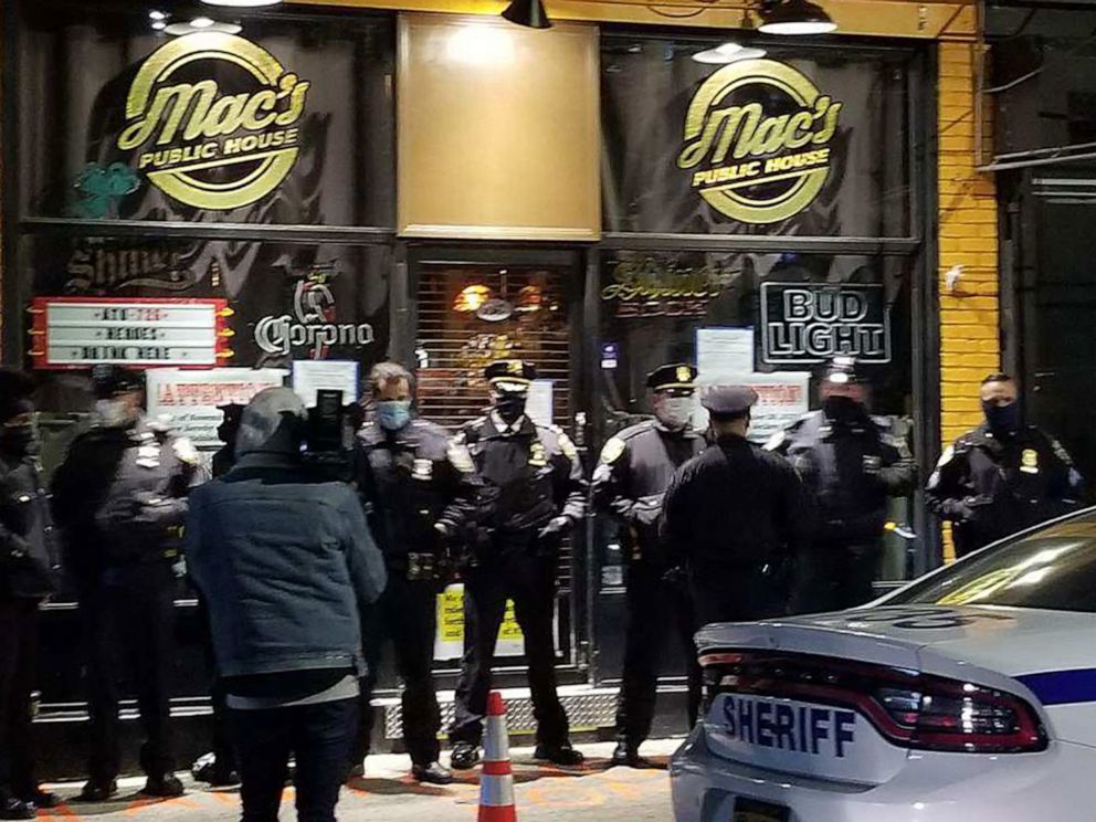 PHOTO: Sheriff's deputies stand outside Mac's Public House in Staten Island, N.Y., Dec. 1, 2020, after shutting the bar down and arresting a co-owner for violating health and safety measures during a surge in COVID-19 infections.