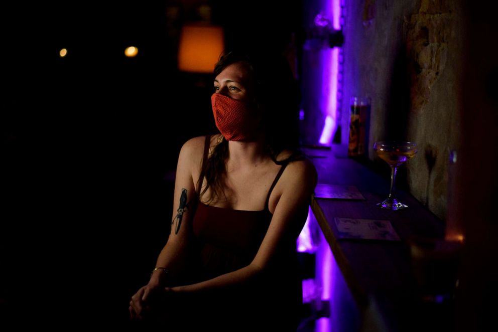 PHOTO: Blair Truesdell enjoys a drink at The Cottonmouth Club wearing a facemask in Houston, on May 22, 2020, amid the novel coronavirus pandemic. 