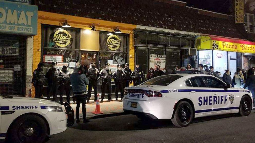 PHOTO: Sheriff's deputies stand outside Mac's Public House in Staten Island, N.Y., Dec. 1, 2020, after shutting the bar down and arresting a co-owner for violating health and safety measures during a surge in COVID-19 infections.