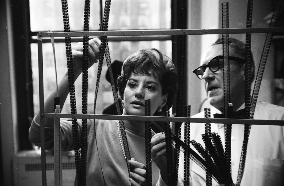 PHOTO: Broadcast journalist Barbara Walters looks at film negatives with an unidentified man behind the scenes at NBC Studios in New York, circa 1966.