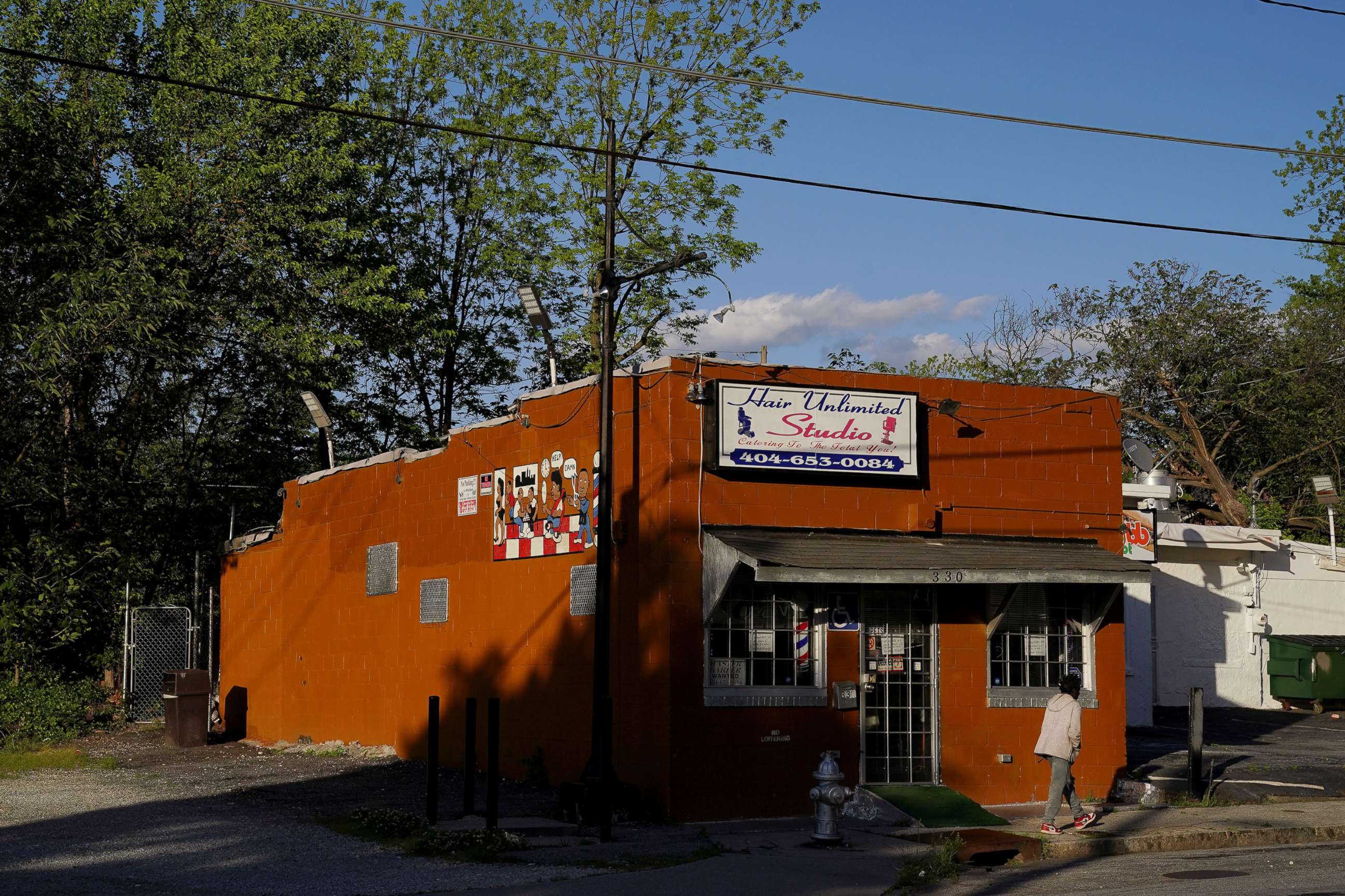 PHOTO: A man walks past a barber shop days before the phased reopening of businesses and restaurants from coronavirus disease (COVID-19) restrictions in Atlanta, Georgia,  April 21, 2020.