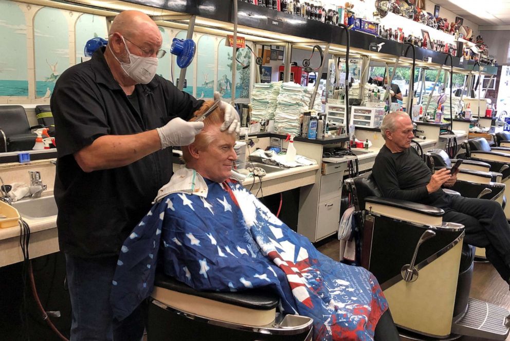 PHOTO: In this April 24, 2020, file photo, barber Tommy Thomas gives his long-time customer Fred Bentley a haircut after the Georgia governor allowed a select number of businesses to open during the COVID-19 restrictions in Atlanta.