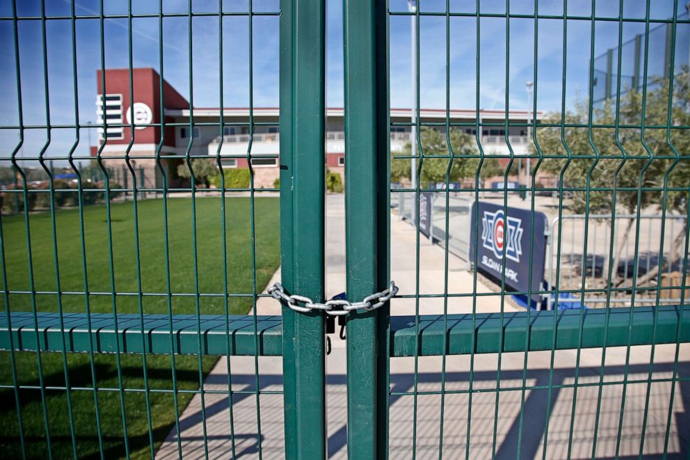 PHOTO: A gate at the Chicago Cubs practice facility at Sloan Park in Mesa, Ariz., is closed and locked, March 16, 2020. The remainder of spring training baseball games have been canceled due to the coronavirus. 